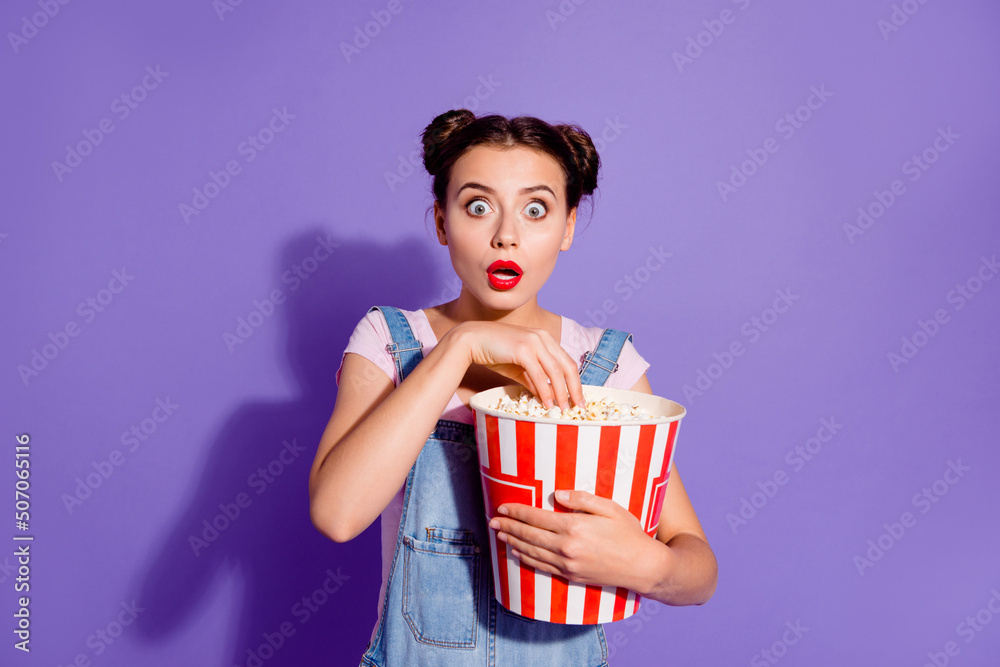Photo of impressed crazy girl open mouth stare speechless eat pop corn isolated on violet color background