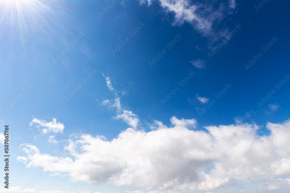 blue sky background. white fluffy clouds above horizon. sunny summer weather at high noon