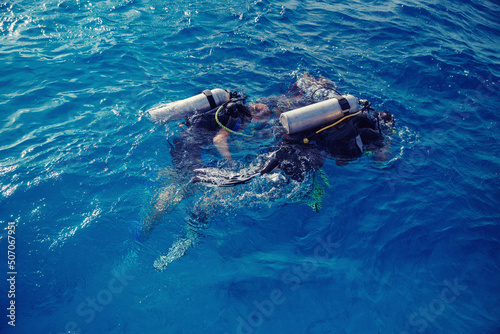 Diving training, instructor instructs tourists to dive underwater with scuba diving in sea, top view