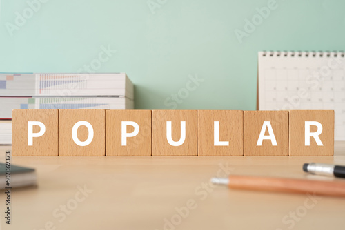 人気のイメージ｜「POPULAR」と書かれた積み木が置かれたデスク photo