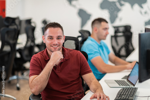 Group of Casual business man working on desktop computer in modern open plan startup office interior. Selective focus 