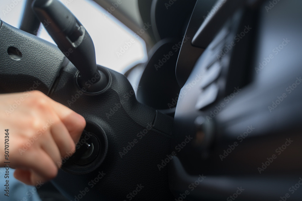 The person starts the car with a key. Close-up - hand under the wheel of the transport