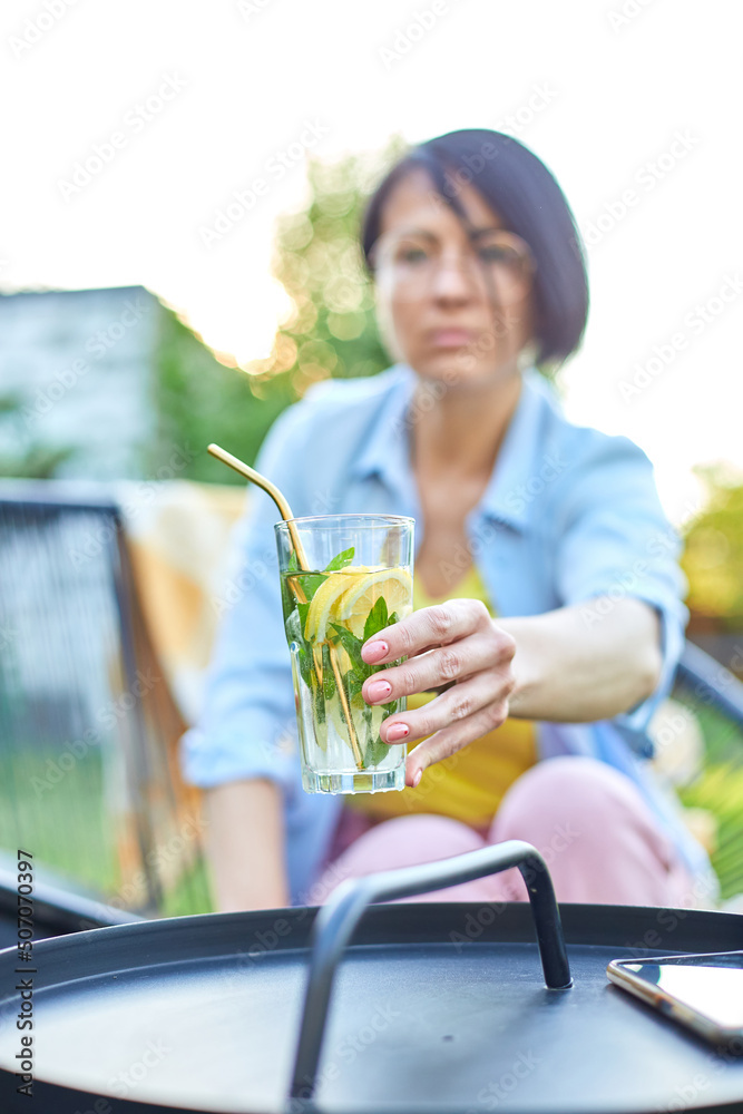 Fototapeta premium Woman take summer citrus lemonade with reusable metal straws