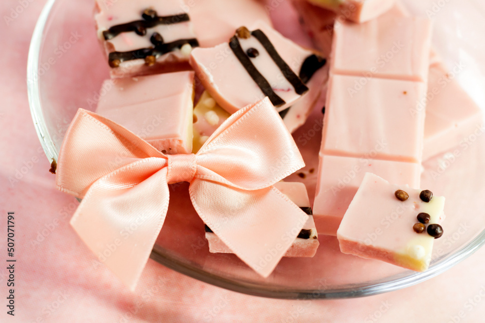 Pink chocolate pieces and a satin bow Pink chocolate pieces and a satin bow