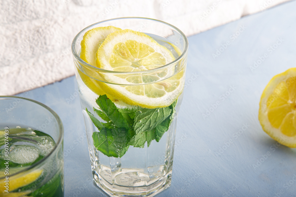 Fototapeta premium Detox lemon, ice and mint drink or mojito with spring color
