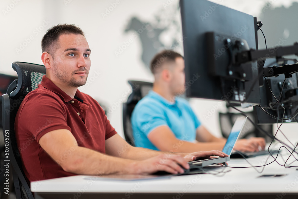 Group of Casual business man working on desktop computer in modern open plan startup office interior. Selective focus Group of Casual business man working on desktop computer in modern open plan startup office interior. Selective focus