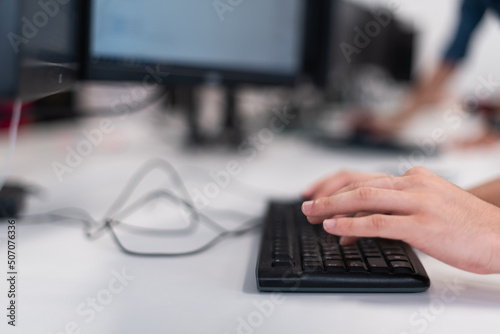 Close up programmer man hand typing on keyboard at desktop pc to input code language into software for study bug and defect of system at office for development of cyber security technology concept