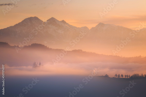 Saint Thomas church on a foggy morning in Slovenia photo
