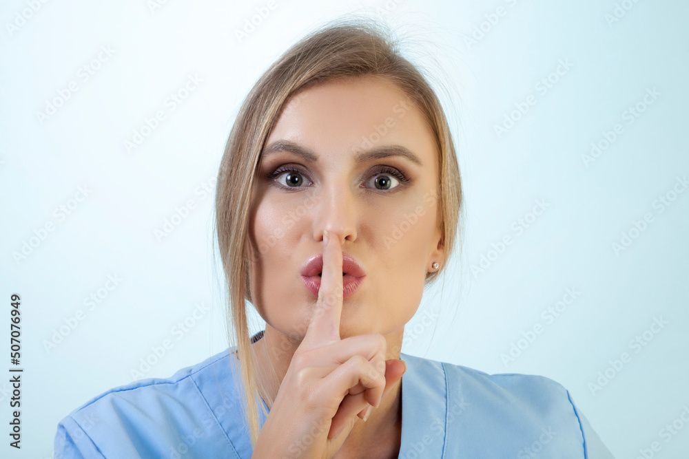 Blonde Nurse is Shushing Against Blue Background