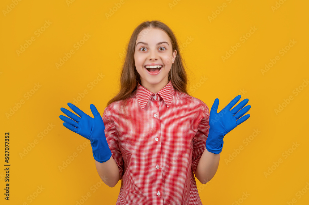 amazed child in rubber gloves on yellow background amazed child in rubber gloves on yellow background