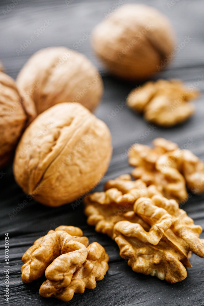 dried walnuts on a black rustic wooden background dried walnuts on a black rustic wooden background