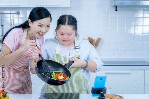 Obraz na plátne Asian person with Down syndrome cooking with mom