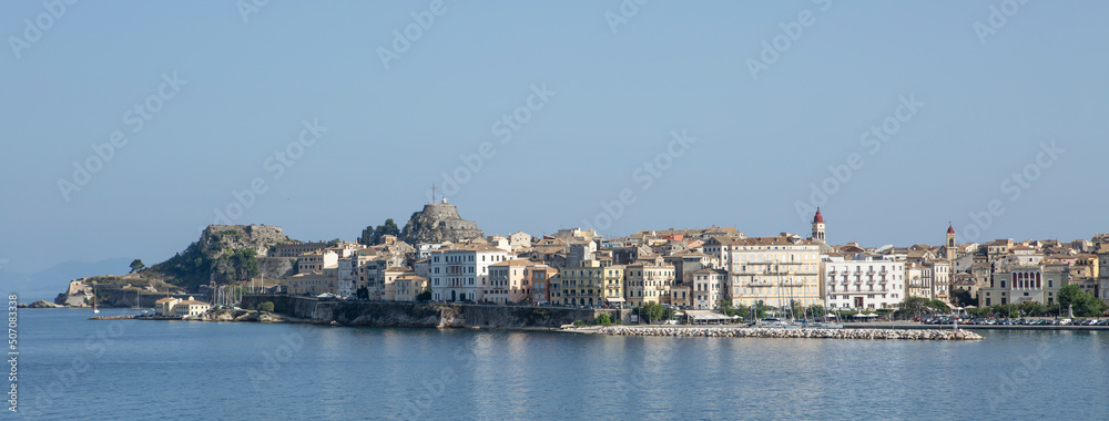 city scape of Corfu taken from sea showing the venetian style buildings and churches on a vivid blue sea