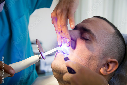 Middle Age Dentist s Patient is Having a Teeth Whitening