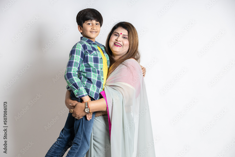 Portrait of happy indian mother and son looking at camera, Isolated on white studio background, Woman wearing sari standing with little kid, togetherness and family concept. Portrait of happy indian mother and son looking at camera, Isolated on white studio background, Woman wearing sari standing with little kid, togetherness and family concept.