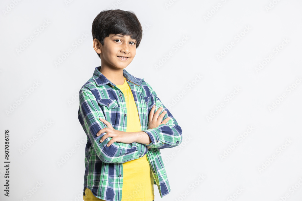 Portrait of smiling cute little indian boy standing with cross arms isolated on white studio background. Portrait of smiling cute little indian boy standing with cross arms isolated on white studio background.