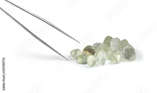Rough Diamond Crystals with Gemmology Tongs Isolated on White Background photo
