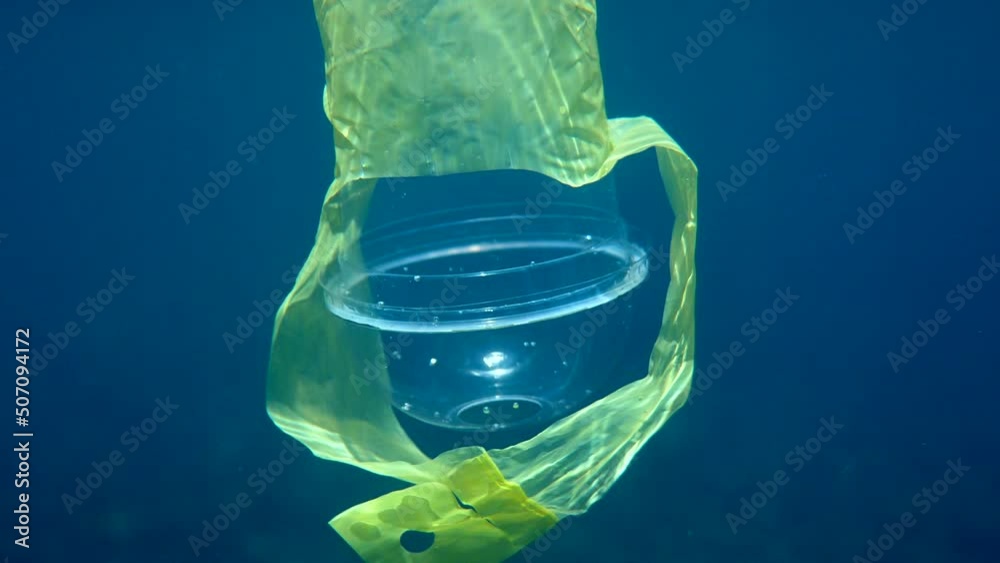 Underwater video of plastic cocktail cup with a plastic holder swimming ...