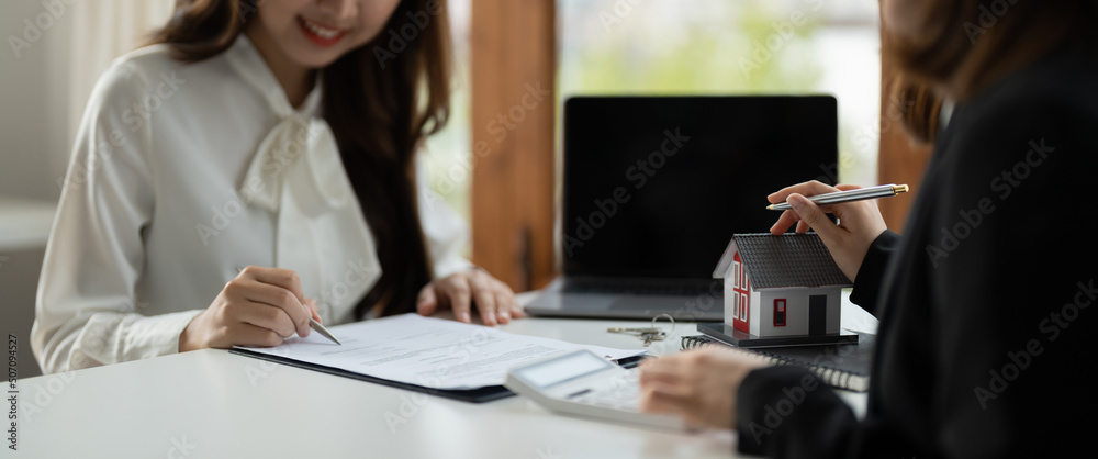 Real estate agent or bank officer describes the loan interest to the customer with home purchase contracts or on office loans and interest rates - obrazy, fototapety, plakaty 