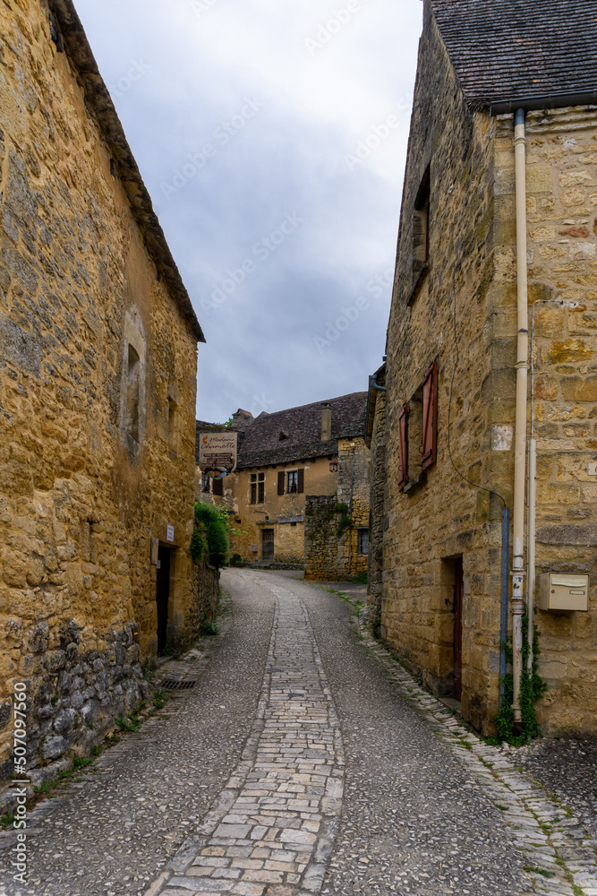 narrow cobblestone street with quaint stone houses in the historic village of Beynac-et-Cazenac
