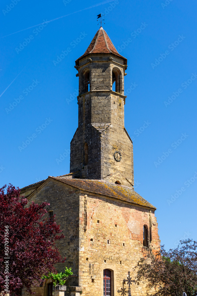 a view of the Our Lady of Capelou Church in Belves under a blue sky