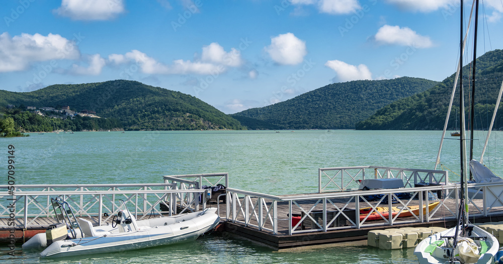 Naklejka premium Empty pier for boats at blue lake water background at sunny summer day