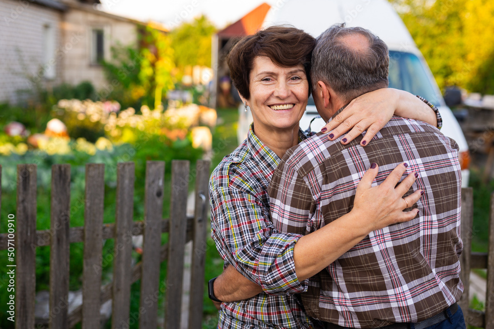 Fototapeta premium mature happy man and woman hugging at the infield near the fence