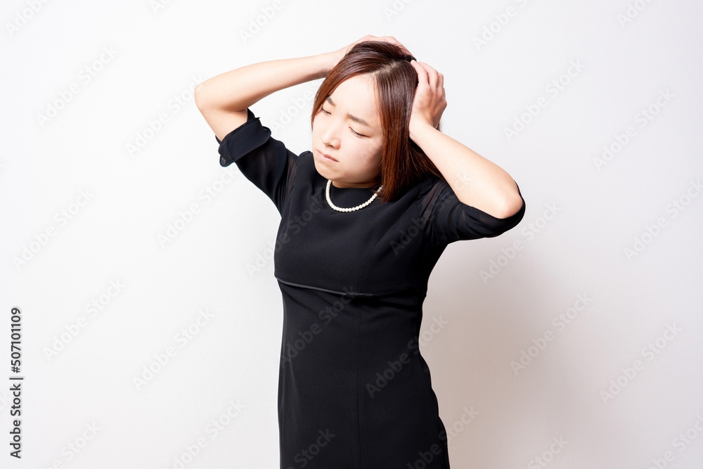 困っているポーズをする喪服を着ている女性