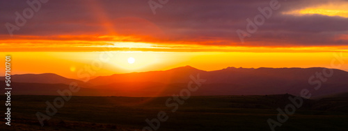 contrasting sunset high in the mountains panorama. Fairy tale dramatic landscape with epic sun rays