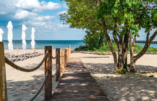 Fototapeta Naklejka Na Ścianę i Meble -  Wooden walkway on sunny sandy beach
