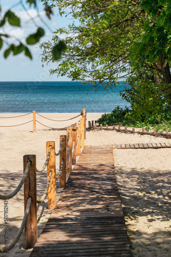 Fototapeta Naklejka Na Ścianę i Meble -  Wooden walkway on sunny sandy beach

