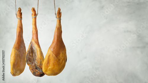 Spanish cured ham hanging against gray background. Copy space