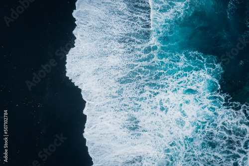Blaues Meer und schwarzer Strand mit der Drohne © Marlon