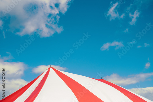 Circus tent under blue sky colorful stripes