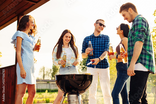 Фототапет Friends have a barbecue party outdoors during outdoor recreation