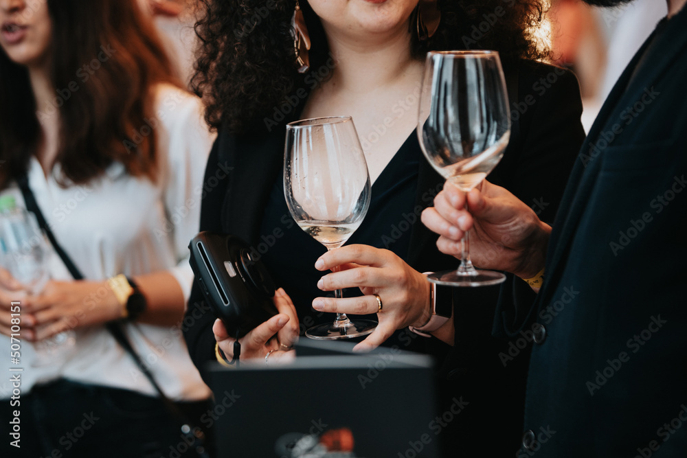 We celebrate success with a glass of rose wine in hand at a special tasting with happy people. We celebrate success with a glass of rose wine in hand at a special tasting with happy people.