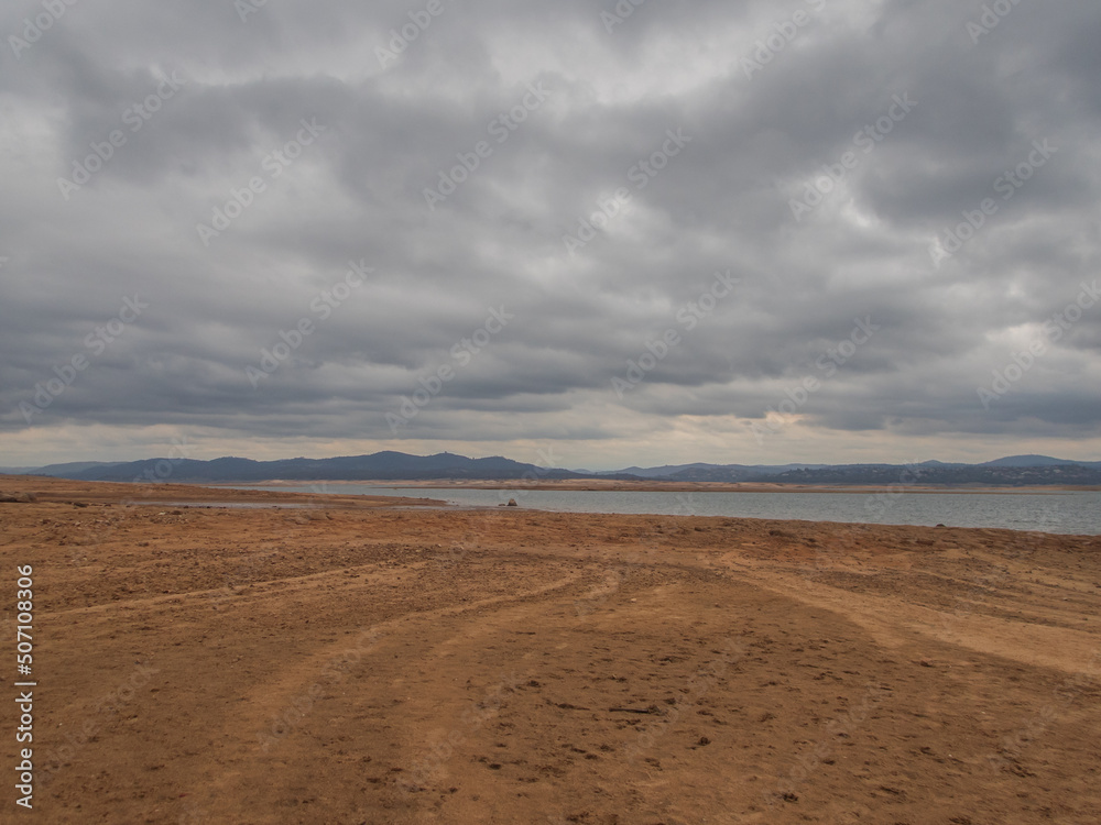 Gloomy shot of Shoreline of Folsom Lake CA really low water.