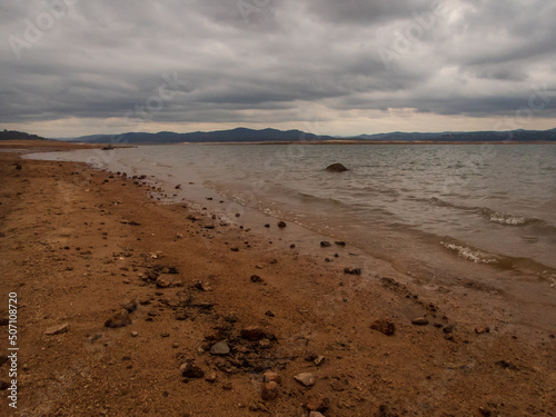 Shoreline of Folsom Lake CA really low water on dark cloudy day.