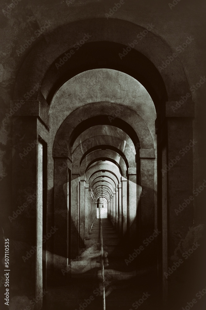 Woman from behind in a corridor with arches