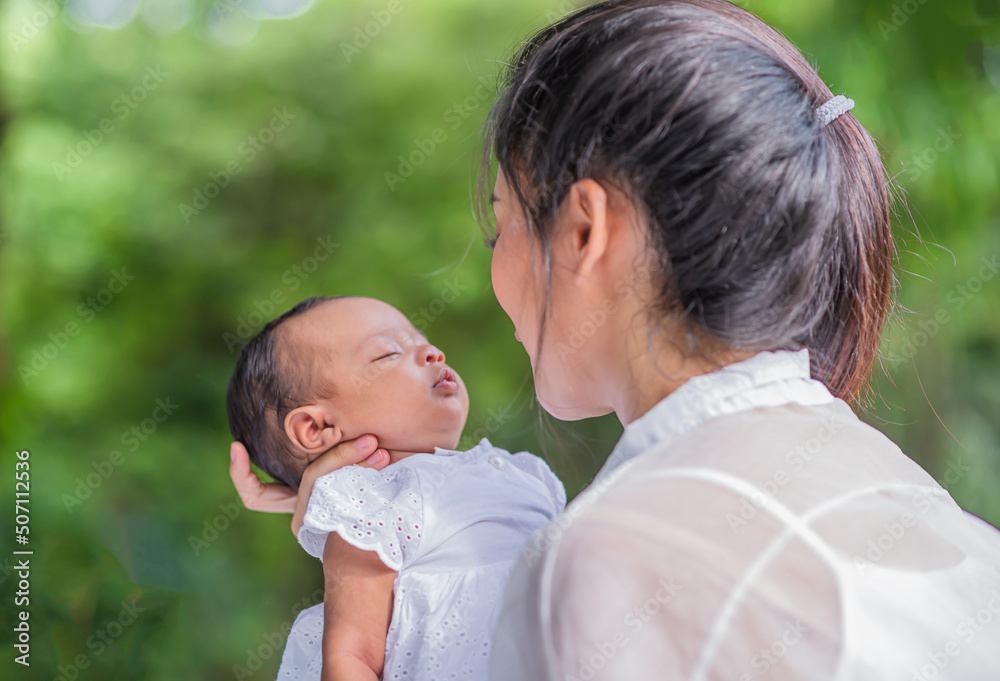 Asian beautiful mother hugs her baby while sleeping