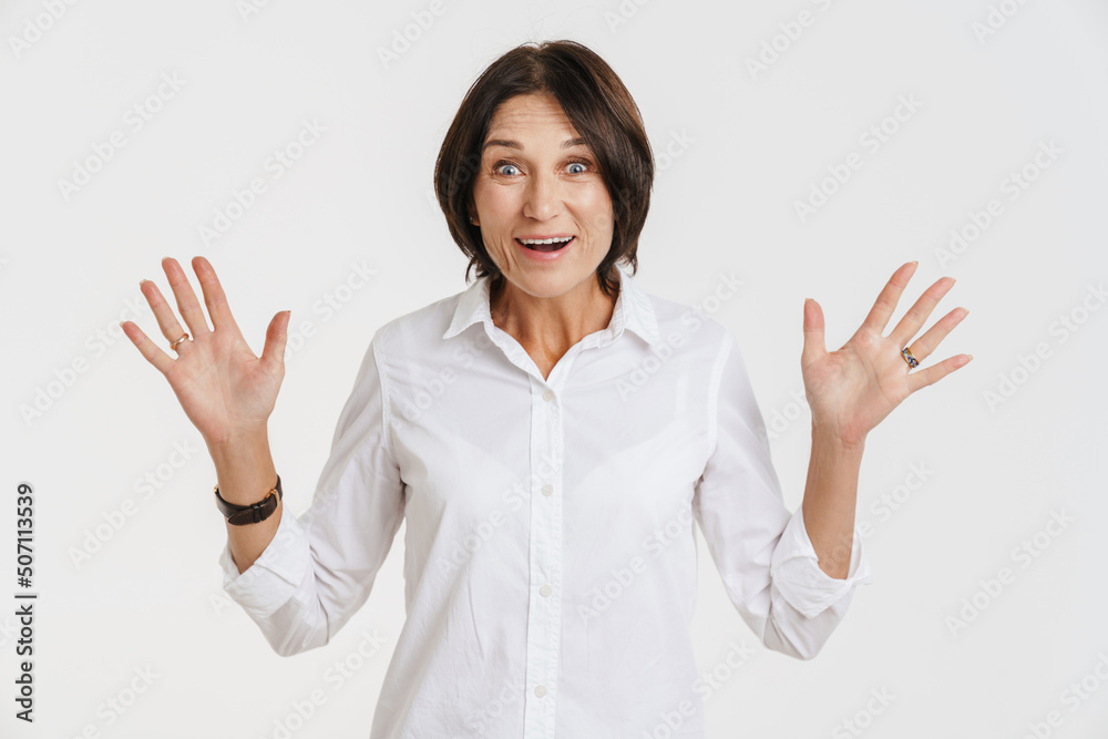 Mature brunette woman gesturing and smiling at camera Mature brunette woman gesturing and smiling at camera