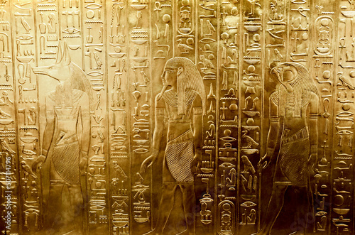 A golden wall with engraved Egyptian gods, the tomb of pharaoh Tutankhamun photo