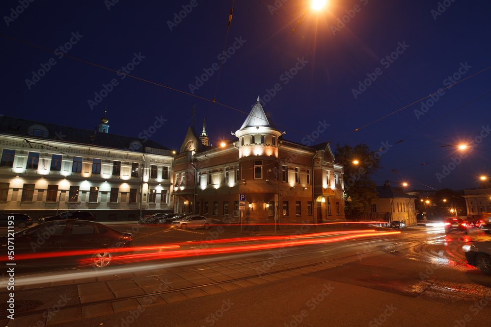 Moscow, Russia - July, 27 2014: Historical buildings in Moscow center at night. Mansion on Yauza boulevard. Tram rails and light traces on foreground.