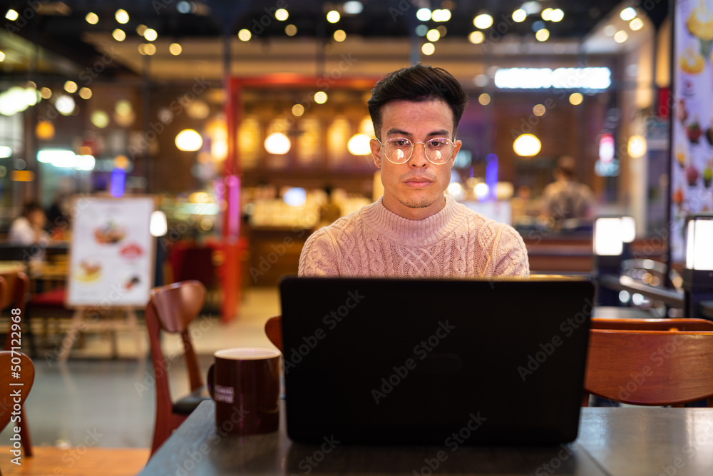 Young man using laptop computer at coffee shop Young man using laptop computer at coffee shop