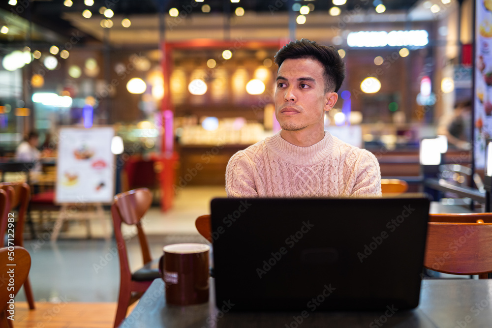Young man using laptop computer at coffee shop Young man using laptop computer at coffee shop