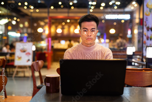 Young man using laptop computer at coffee shop