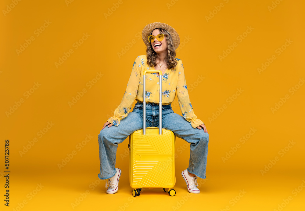 smiling woman traveling with suitcase dressed in trendy outfit on bright yellow background, positive summer vacation smiling woman traveling with suitcase dressed in trendy outfit on bright yellow background, positive summer vacation