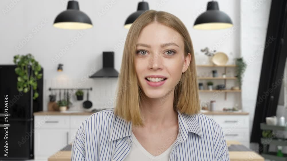 Smiling young caucasian woman blogger sits at home speaking looking at camera. Vlogger in zoom video. Influencer talking making chat, conference call recording lifestyle blog vlog, webcam view 4k 