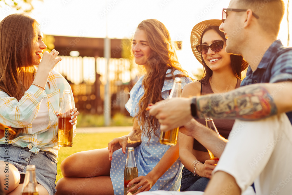 group of friends are enjoying pizza in the park. Men and women sit on the grass around a pizza box group of friends are enjoying pizza in the park. Men and women sit on the grass around a pizza box