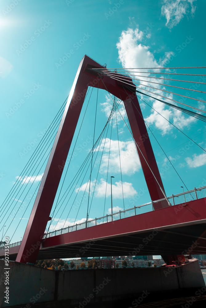 Fototapeta premium Clouds over red bridge in Rotterdam